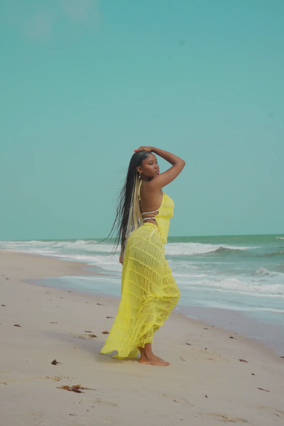 Full length in the yellow gown, walking on the sand