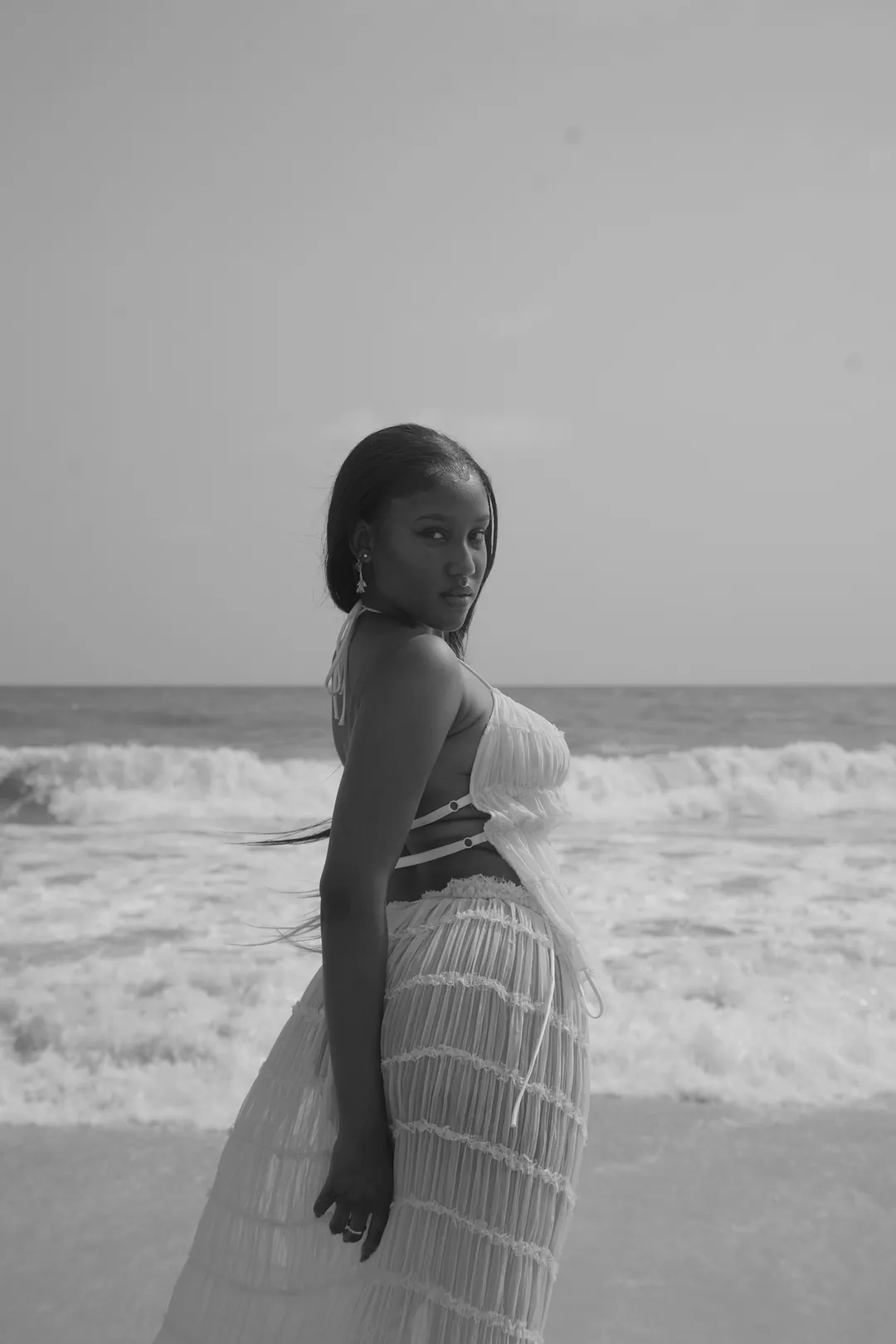 Black-and-white portrait by the sea, looking back