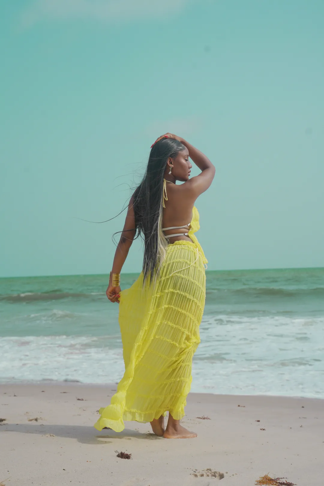 Standing at the shoreline, one hand in her hair