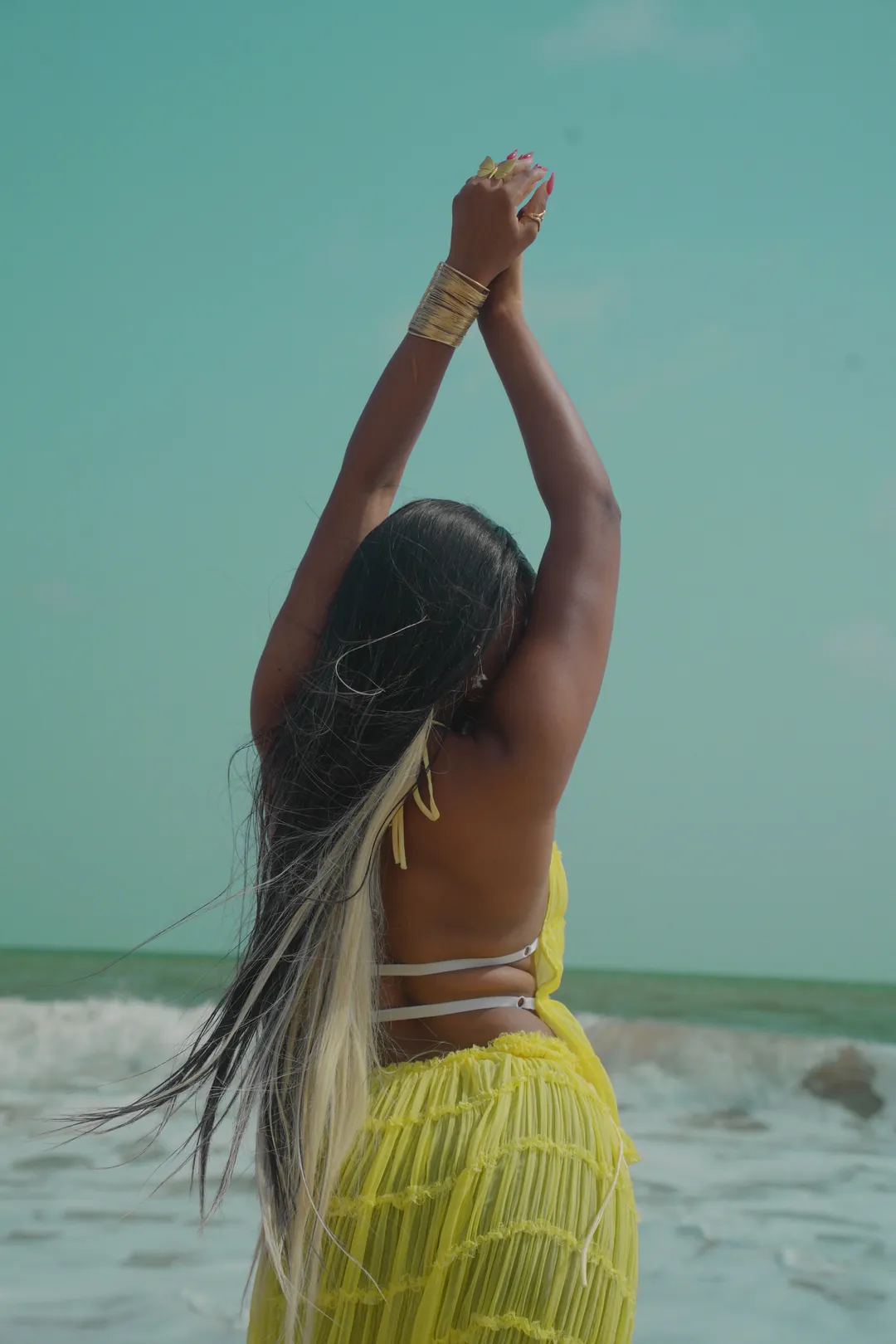 Arms raised to the sky, long hair down her back